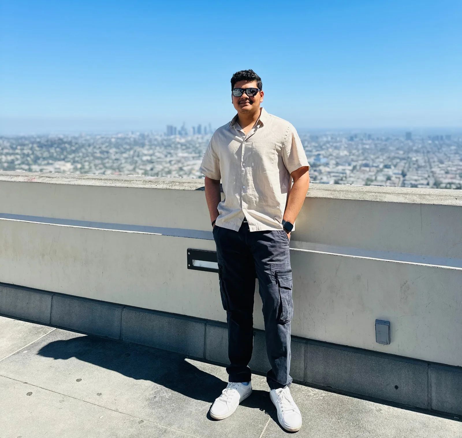 Prakhar Jain standing on a rooftop with the city skyline fully visible behind him.