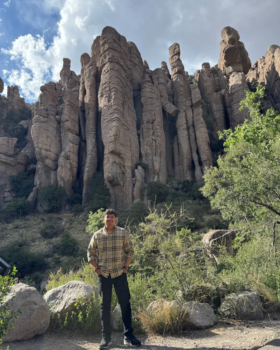 Prakhar Jain standing within a mountain landscape with the major rock formations and full person visible.